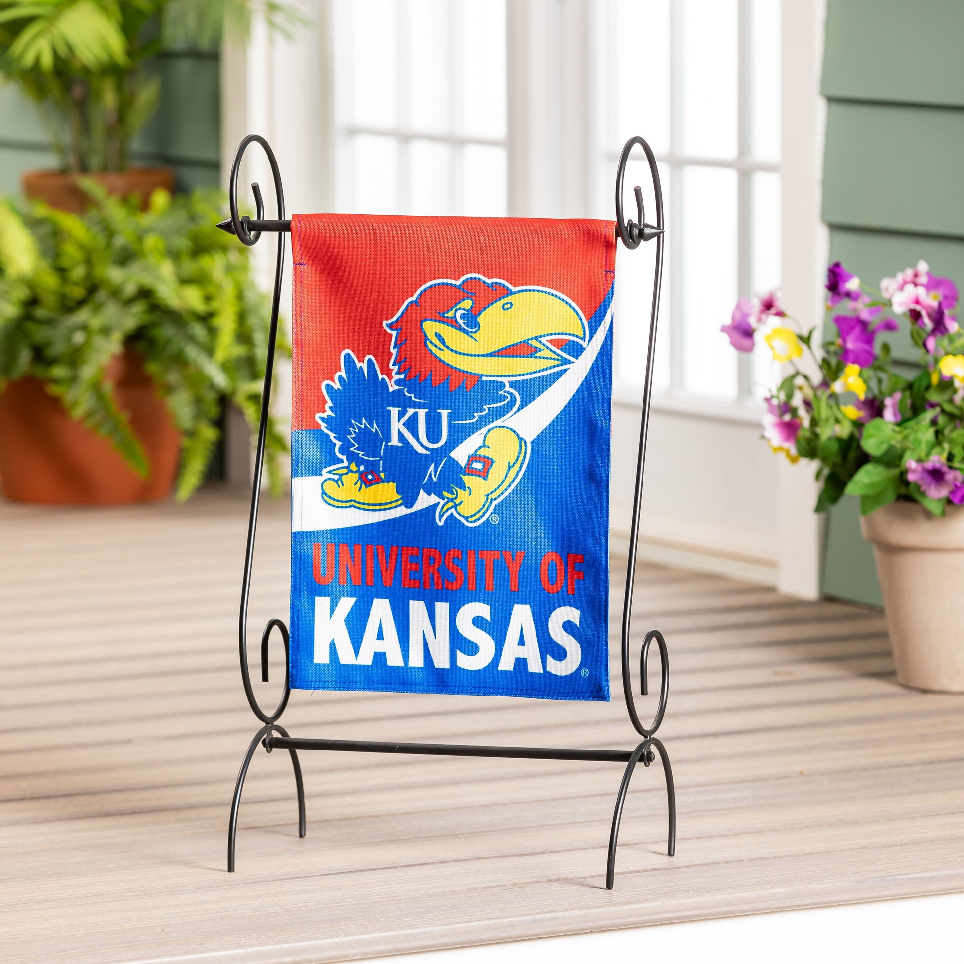 University of Kansas burlap garden flag with Jayhawk logo on black metal stand on Tampa Home & Garden Store
