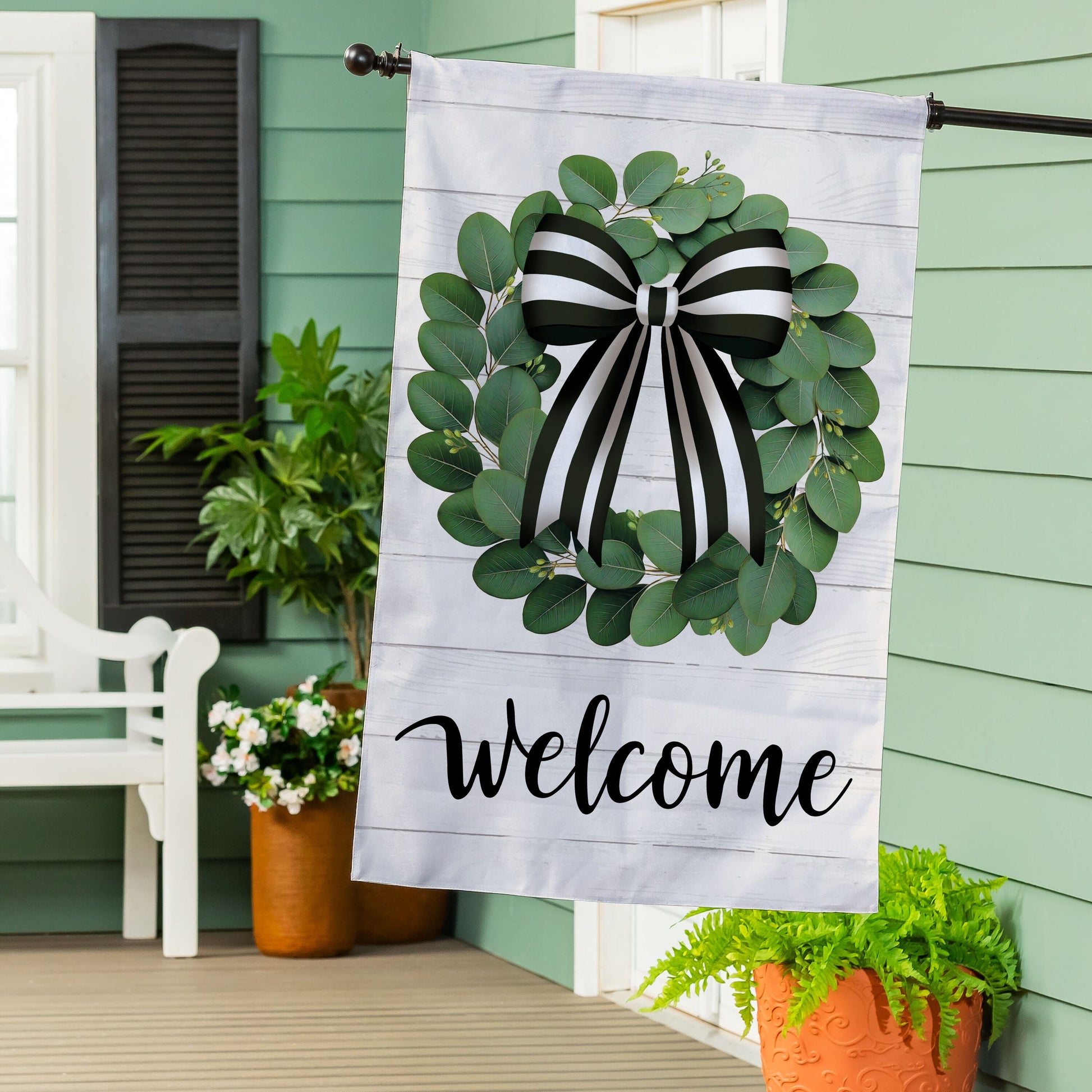 Eucalyptus leaves wreath burlap flag with black and white striped bow on light wood background on Tampa Home & Garden Store