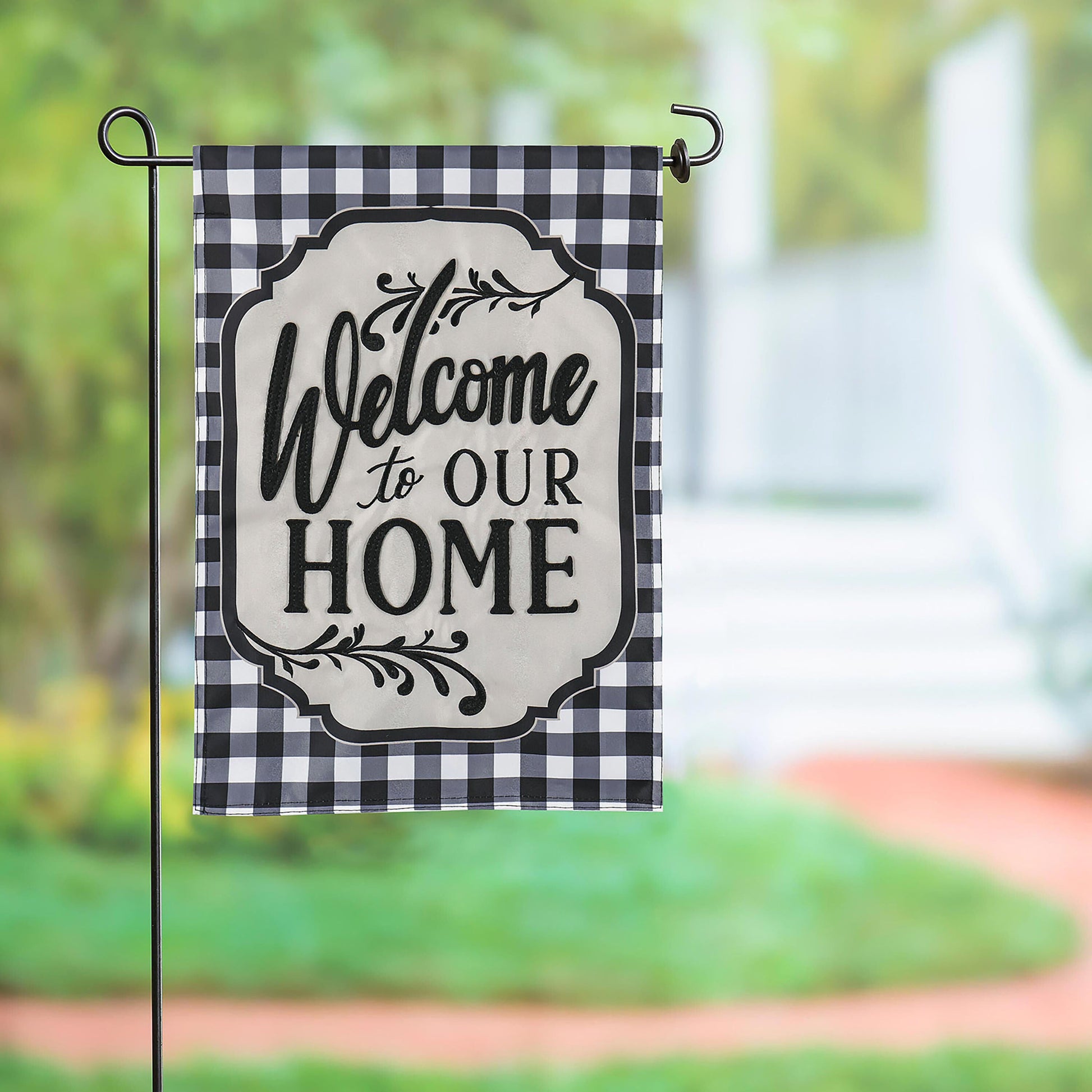Classic Welcome Home garden applique flag with black-white gingham border on a black metal post on Tampa Home & Garden Store