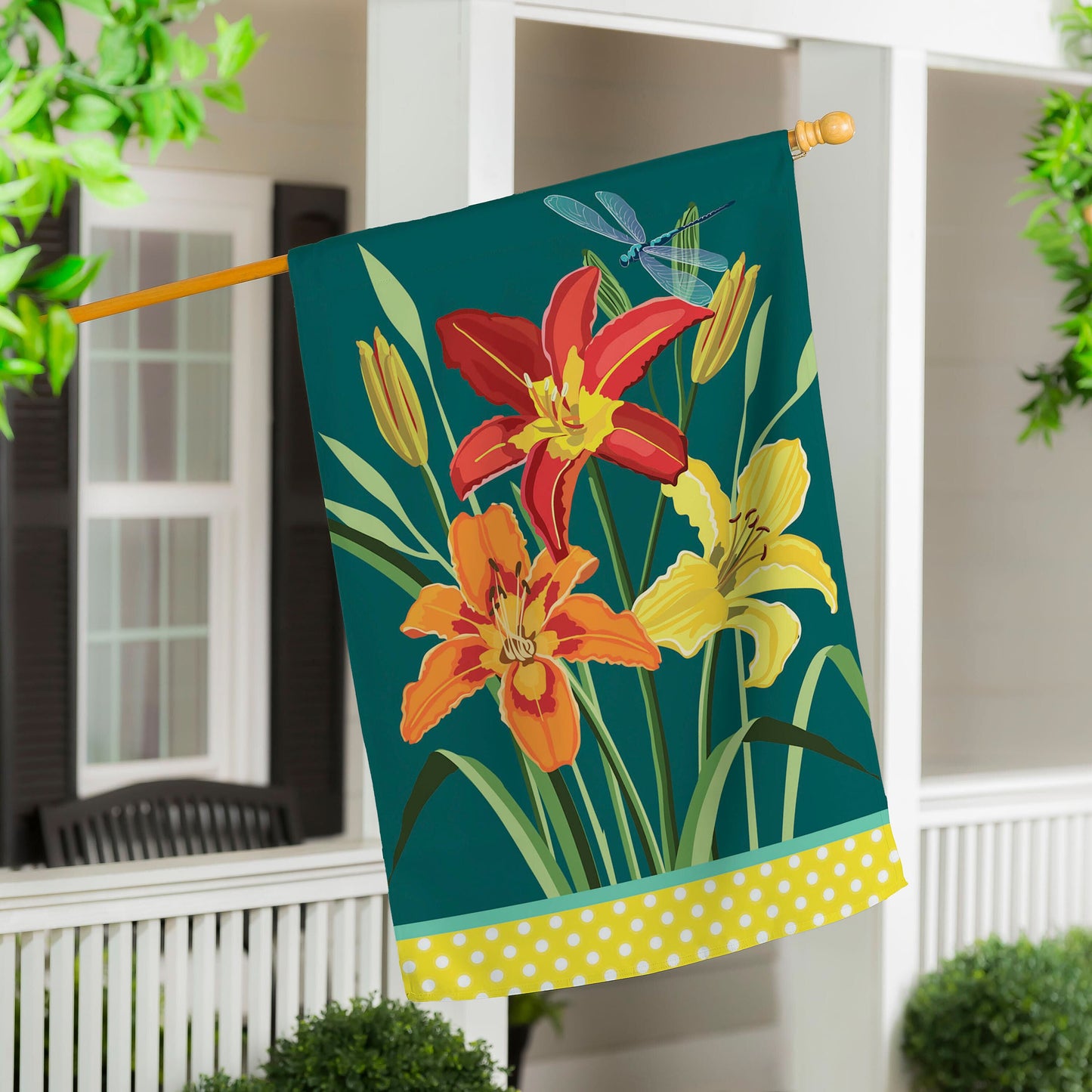Daylilies Applique Flag teal background with blooms and yellow polka-dot hem on wooden pole on Tampa Home & Garden Store
