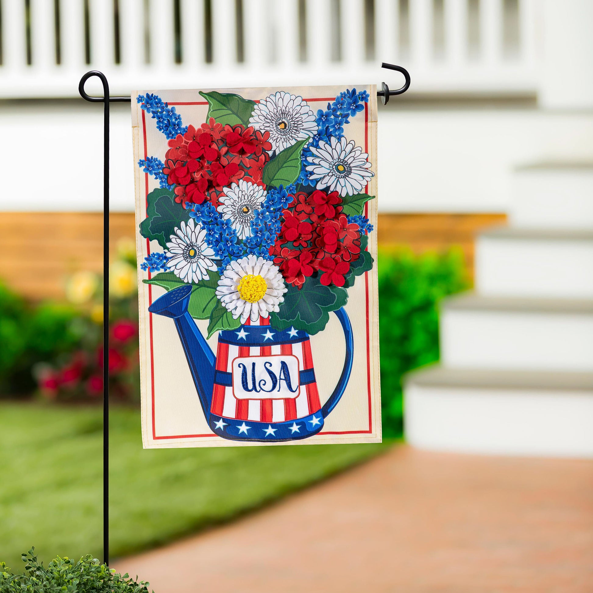 USA Floral Watering Can Applique House Flag featuring red and white striped watering can with white daisies and blue blossoms on Tampa Home & Garden Store