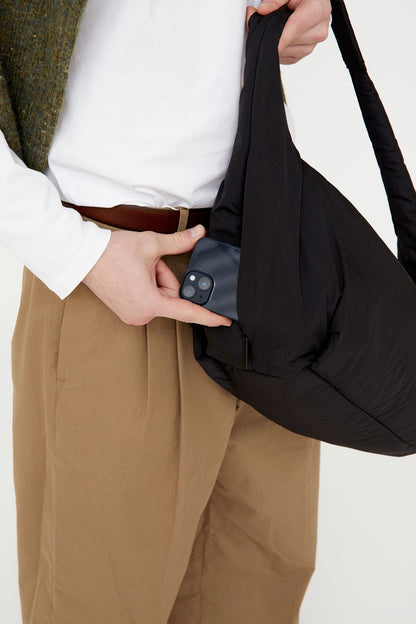 Myra Bag black recycled shoulder bag with slouchy silhouette and pocket, phone tucked in on Tampa Home & Garden Store