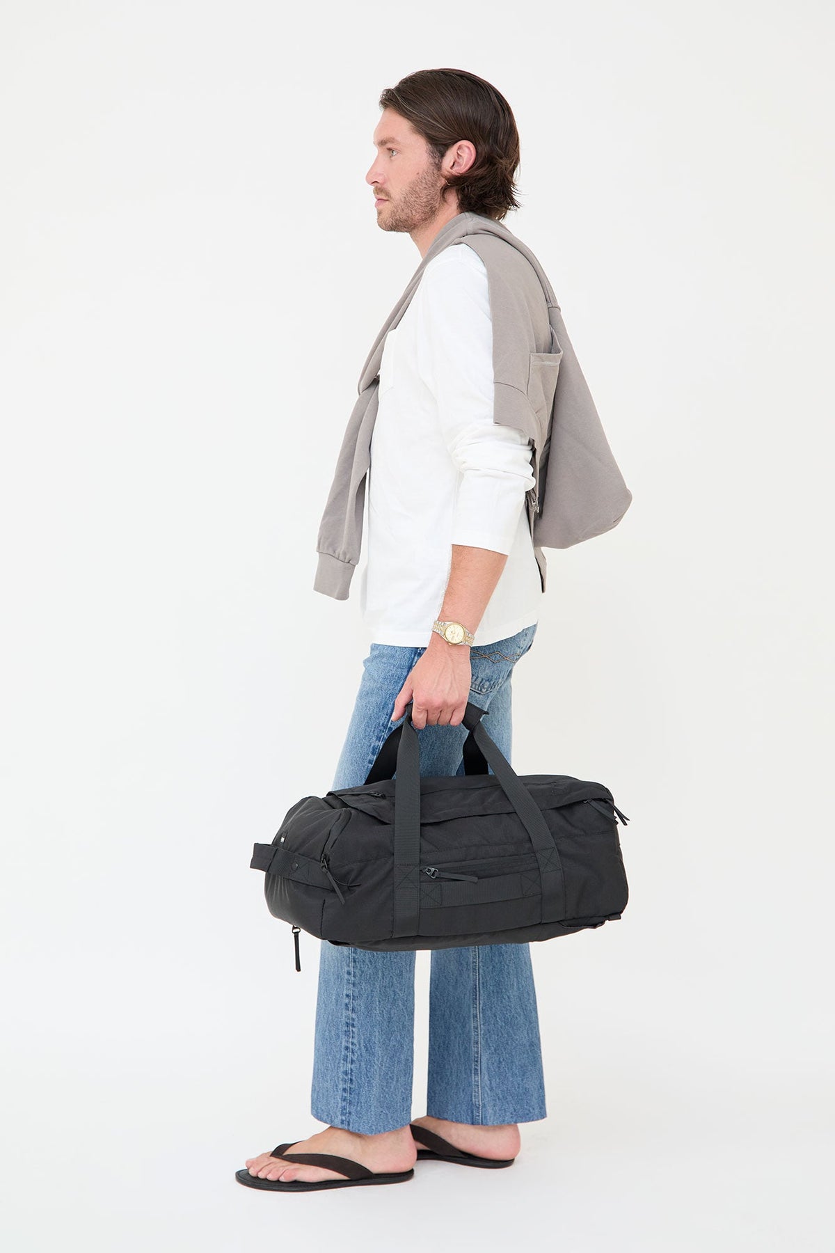 Wanderer Travel Backpack 29L by Lefrik USA gray laptop backpack on model, with black duffel bag on Tampa Home & Garden Store