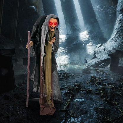 Life size animatronic witch with red glowing eyes, tattered cloak and staff in a forest on Tampa Home & Garden Store