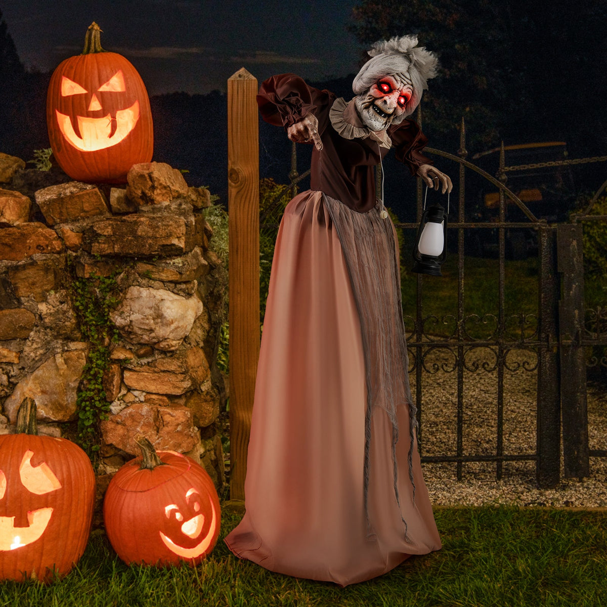 Life-size Halloween hag prop with red eyes, brown gown, lantern near pumpkins on Tampa Home & Garden Store