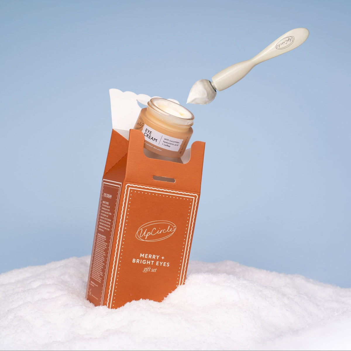 UpCircle Merry + Bright Eyes Gift Set eye cream in orange box with white spatula blue sky on Tampa Home & Garden Store