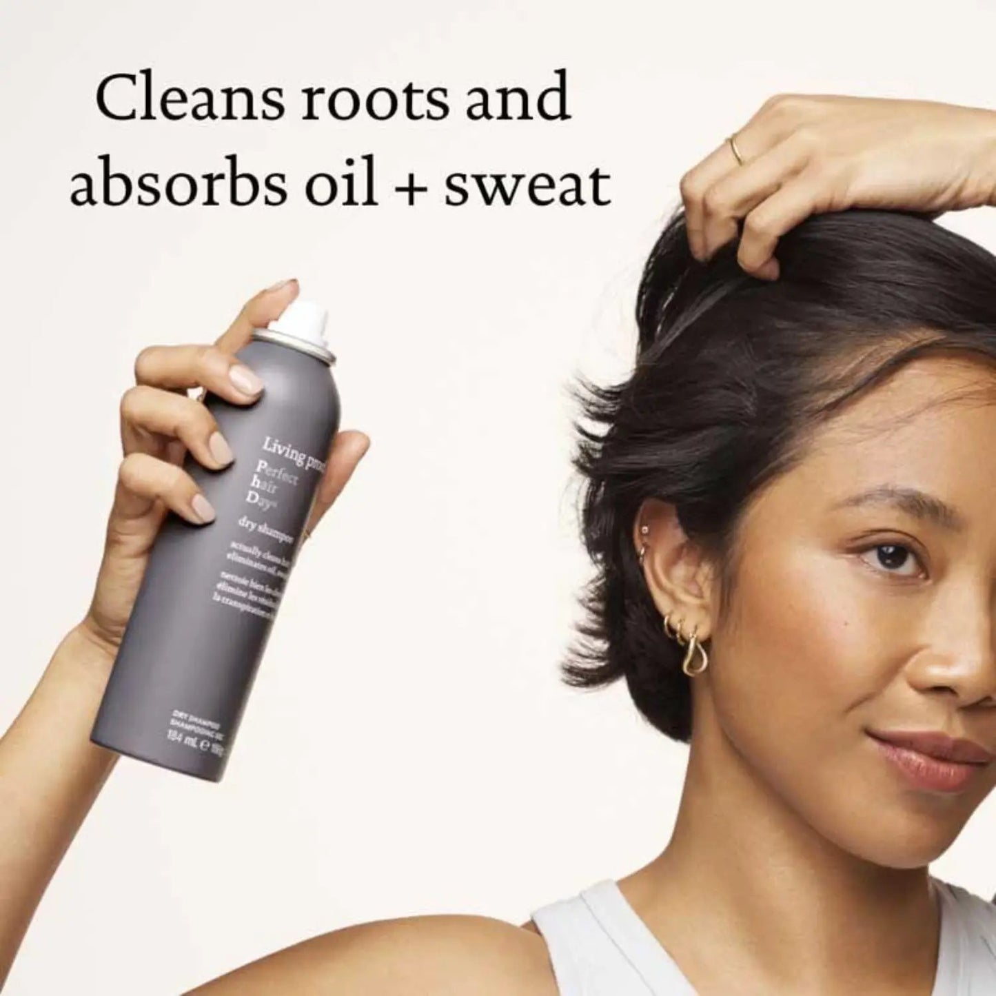Living Proof Perfect Hair Day Dry Shampoo gray spray bottle held by hand beside a woman with short dark hair on Tampa Home & Garden Store