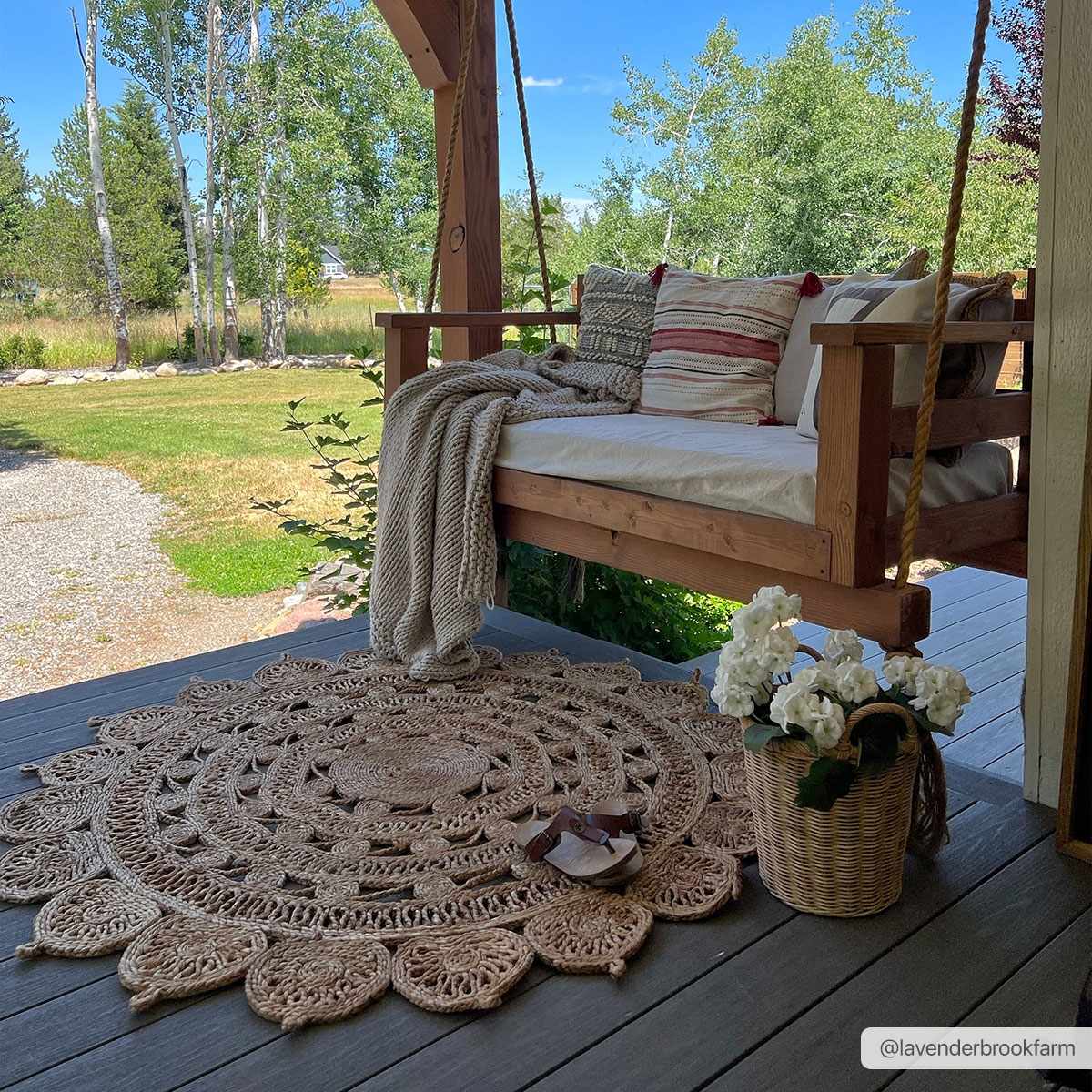 Longville Round Jute Rug by Boutique Rugs, natural beige rug on a porch with a swing on Tampa Home & Garden Store