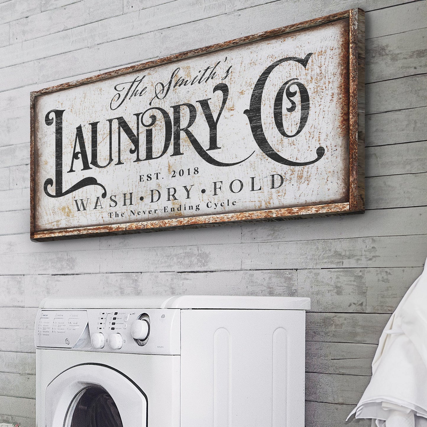 The Never Ending Cycle Laundry Sign canvas with black typography on a white panel above a washer on Tampa Home & Garden Store