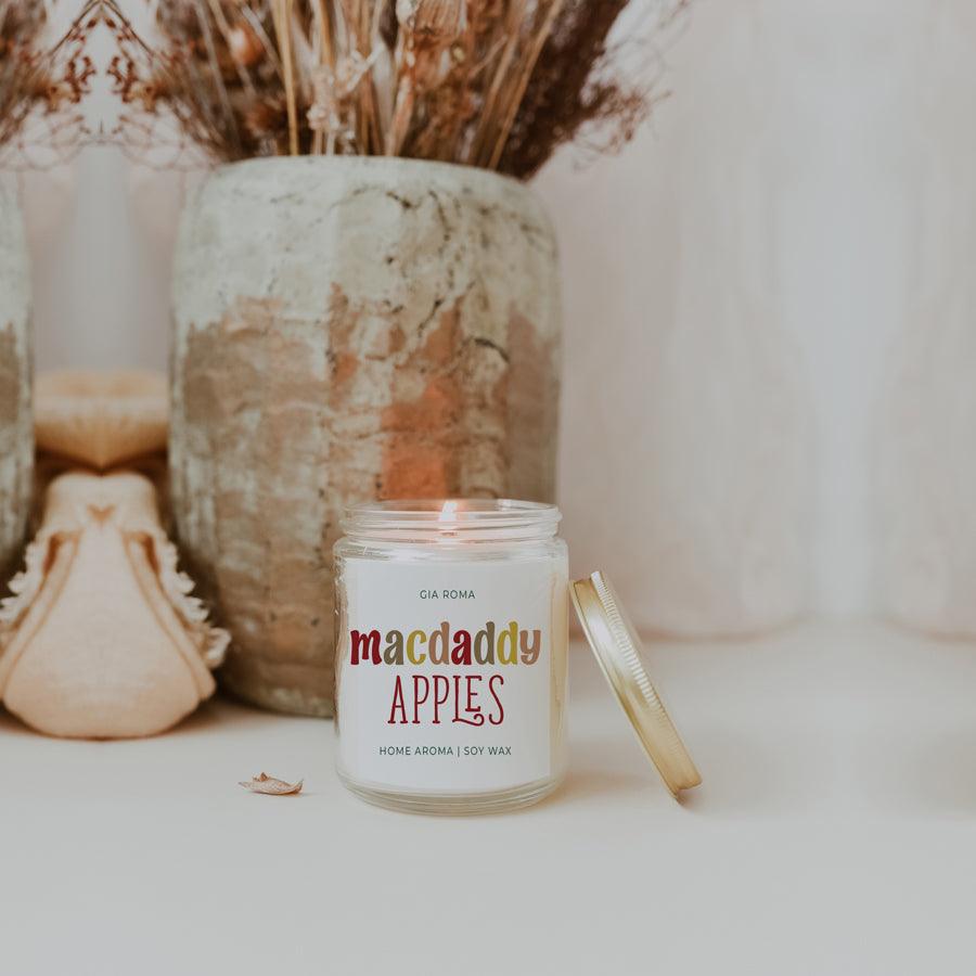 Mac Apple Candle by Gia Roma in a clear glass jar with a gold lid beside on white surface on Tampa Home & Garden Store