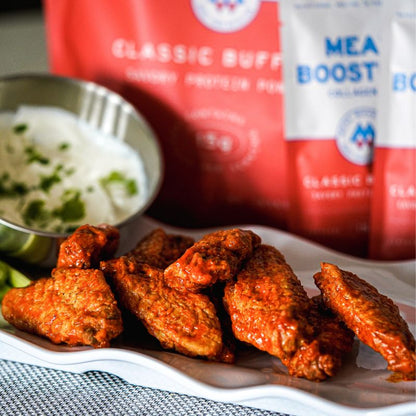 Meal Boosters Classic Buffalo Collagen+ Protein Blend bags visible behind buffalo wings on Tampa Home & Garden Store