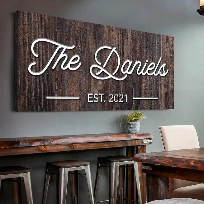 Wooden family name sign with white script lettering The Daniels on dark wood panel on Tampa Home & Garden Store