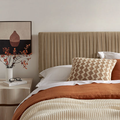 Eloise stain-resistant velvet headboard in beige with vertical channel tufting in a bedroom on Tampa Home & Garden Store