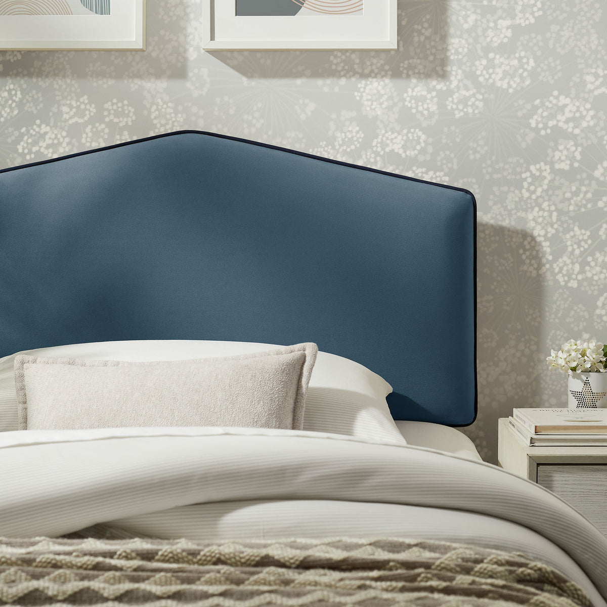 Cosette Performance Velvet Headboard in blue velvet with dark piping against patterned wallpaper on Tampa Home & Garden Store