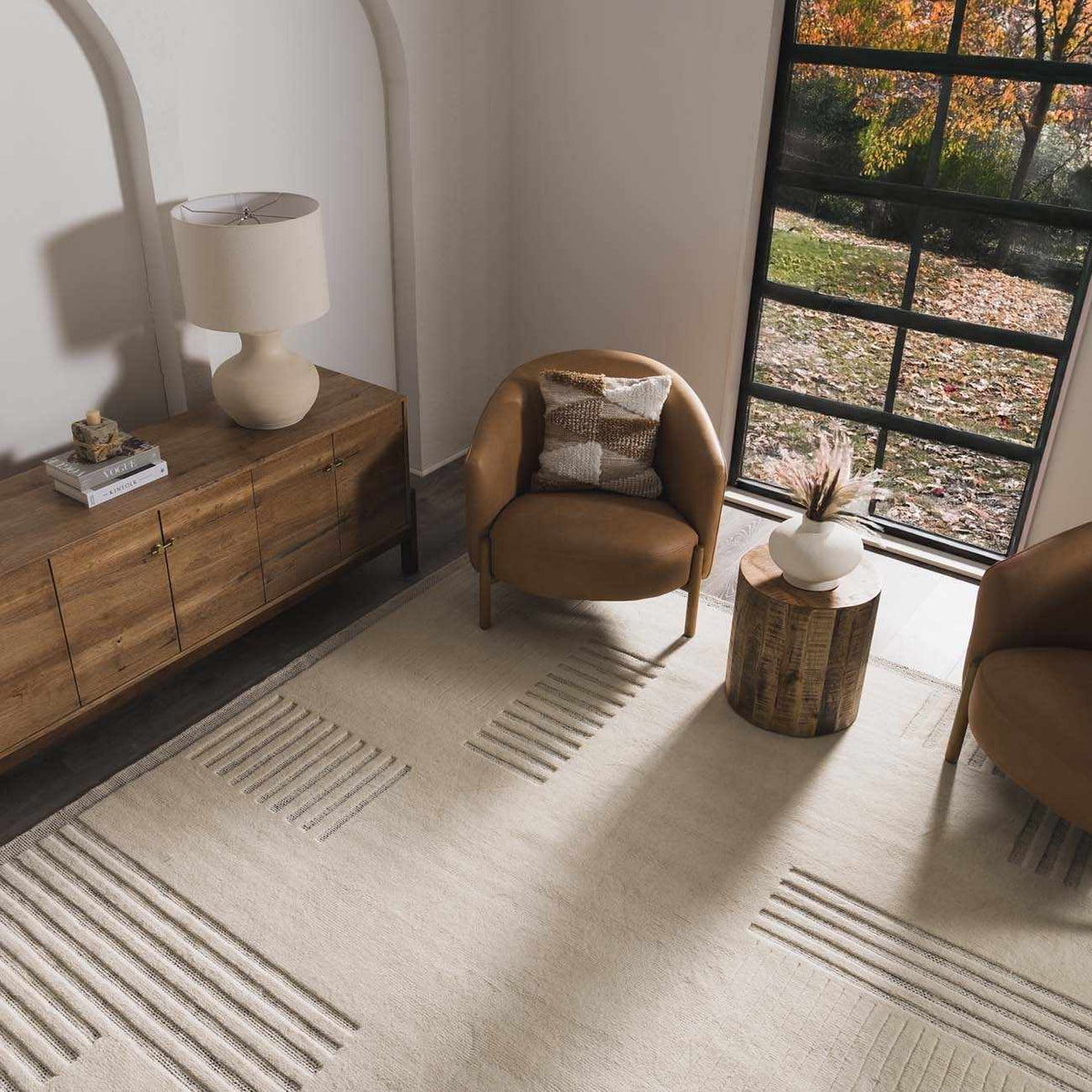 Yulia Wool Area Rug by Boutique Rugs, cream with subtle linear stripes, in a modern living room on Tampa Home & Garden Store