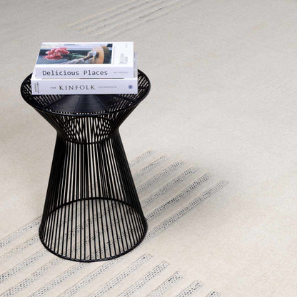 Yulia Wool Area Rug on beige textured floor with a black wire pedestal table and magazines on Tampa Home & Garden Store