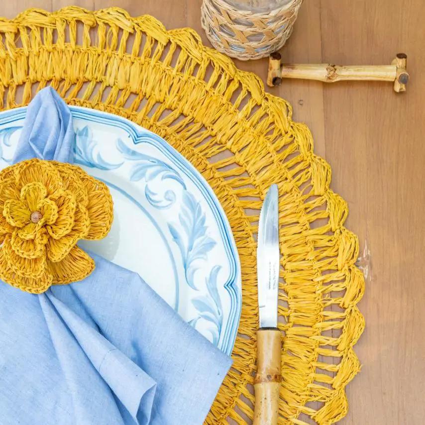 Buriti straw placemats by Talah Home, yellow woven mats with blue plate and napkin on Tampa Home & Garden Store