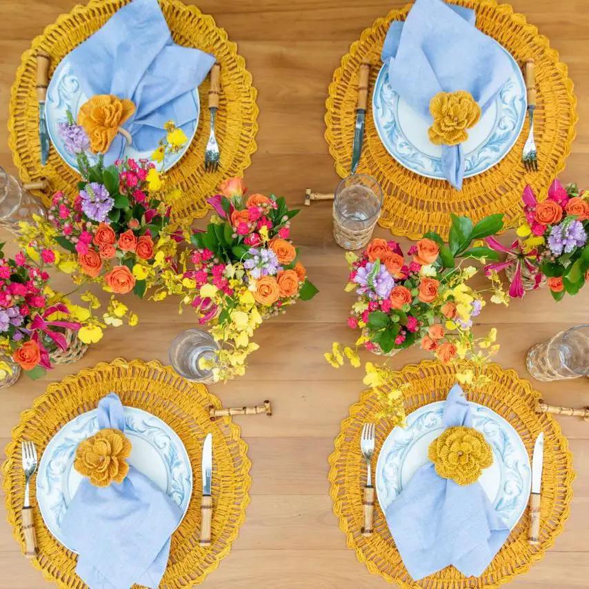 Buriti straw placemats by Talah Home, handcrafted set of four with yellow rims and blue napkins on Tampa Home & Garden Store