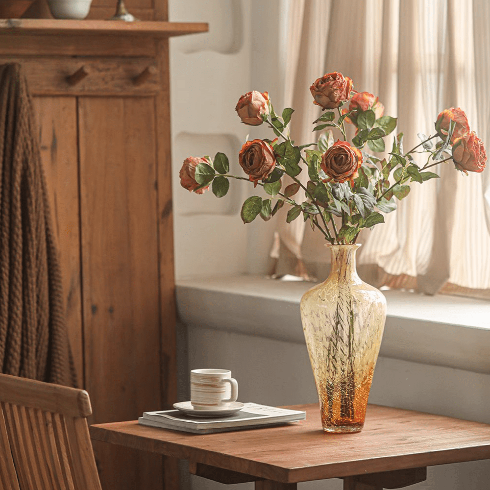 Artificial rose stem bouquet with multiple orange roses in an amber glass vase on a wooden table on Tampa Home & Garden Store
