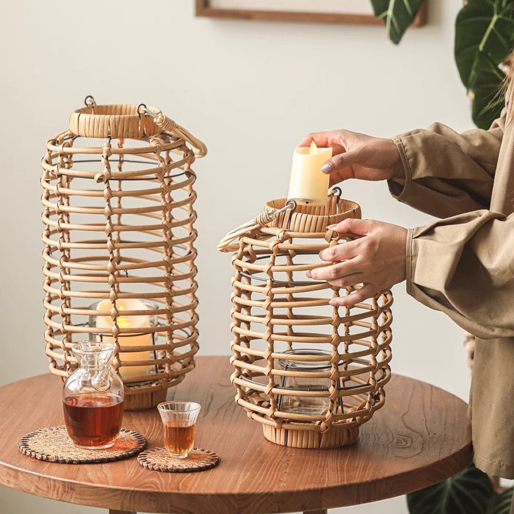 Two natural bamboo woven lantern holders tall and short with handles, candlelit on wood table on Tampa Home & Garden Store
