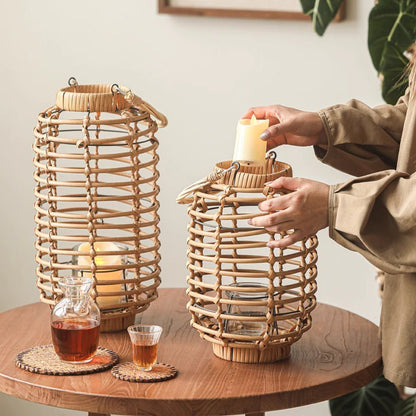 Two natural bamboo woven lantern holders tall and short with handles, candlelit on wood table on Tampa Home & Garden Store