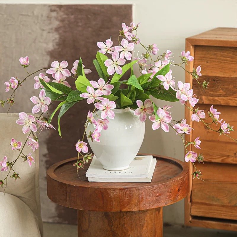 Artificial Cytha Jasmin Stem with pink blossoms and green leaves in a white vase on a wooden table on Tampa Home & Garden Store