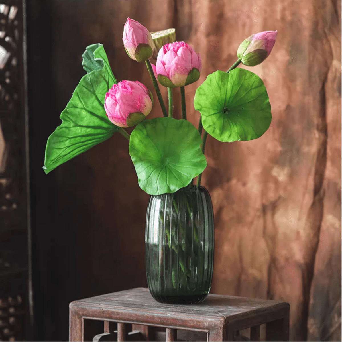 Artificial lotus flower and seedpod arrangement in a dark green ribbed vase with pink buds on Tampa Home & Garden Store