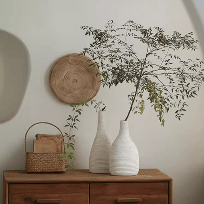 Narrow-neck white ribbed ceramic vases, RusticReach, with greenery on a wooden dresser on Tampa Home & Garden Store