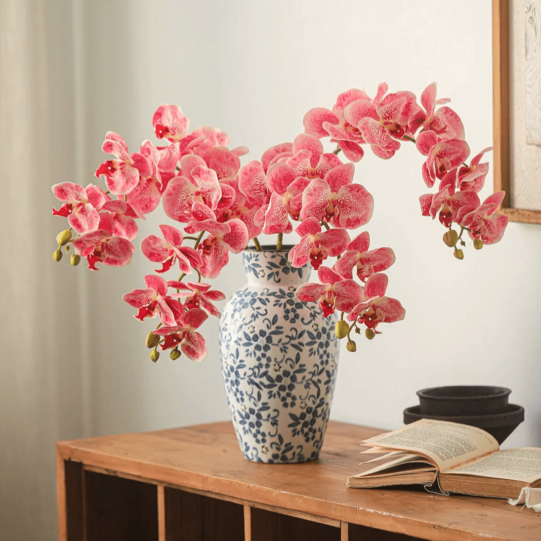 Real Touch Orchid Stem pink blossoms in a blue-and-white ceramic vase on a wooden table on Tampa Home & Garden Store