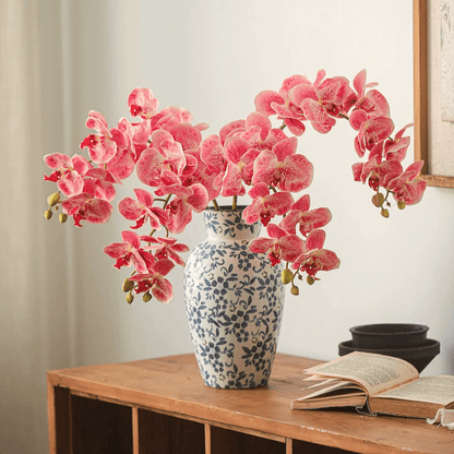 Real Touch Orchid Stem pink blossoms in a blue-and-white ceramic vase on a wooden table on Tampa Home & Garden Store