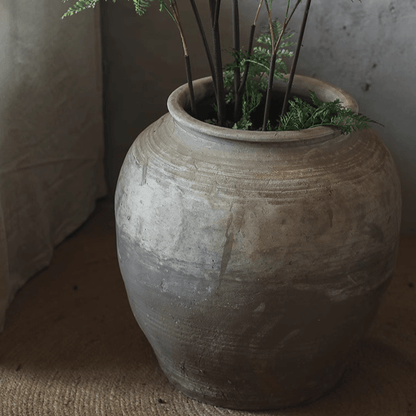 Round earthenware pot by RusticReach in gray glaze with earthy banding; plant stems visible on Tampa Home & Garden Store