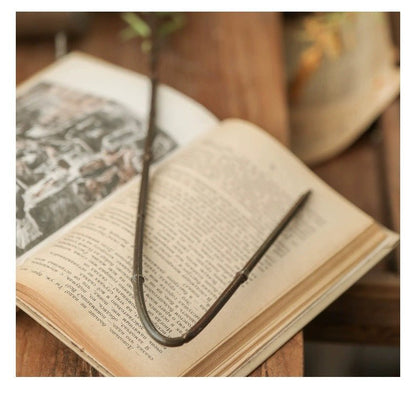 Artificial Large Rosemary Stem 49-inch RusticReach dark green resting on a book on Tampa Home & Garden Store