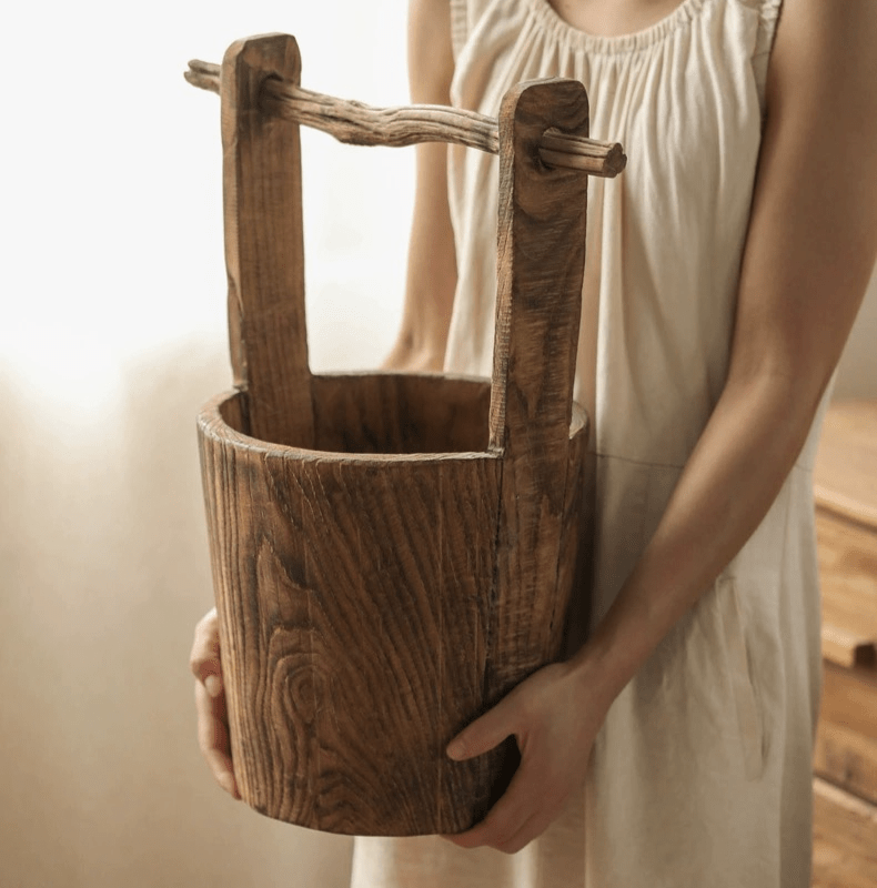 Old-fashioned wooden round bucket with grain and crossbar, held by a person in beige on Tampa Home & Garden Store