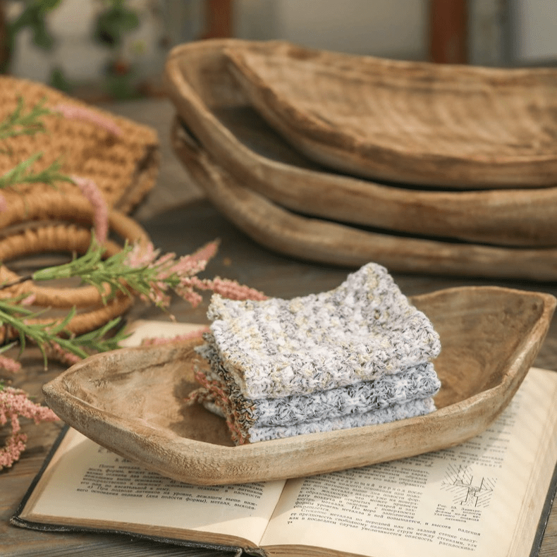 Retro wooden boat-shaped fruit platter in natural wood finish with a stack of gray knit cloths on Tampa Home & Garden Store