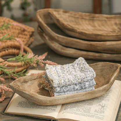 Retro wooden boat-shaped fruit platter in natural wood finish with a stack of gray knit cloths on Tampa Home & Garden Store