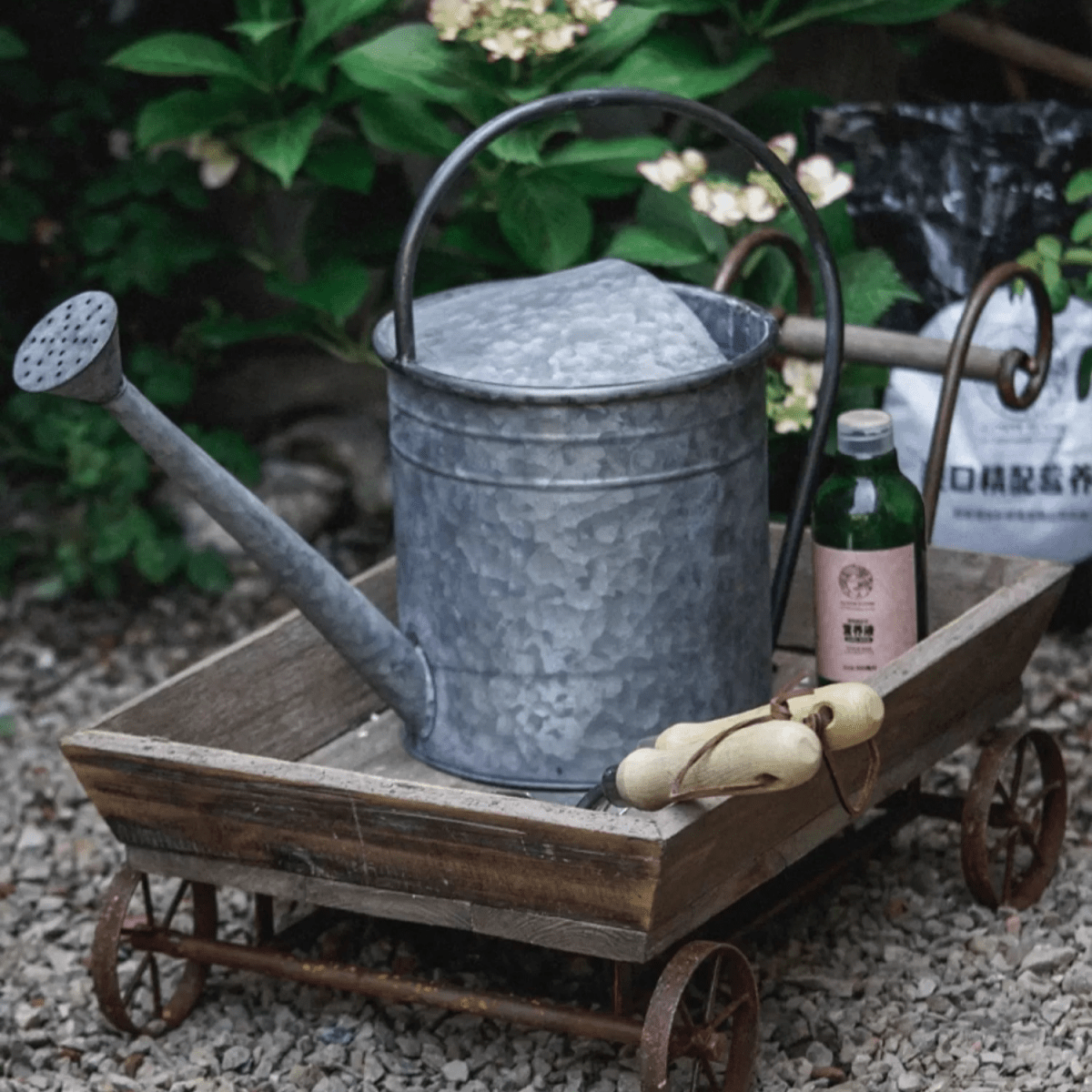 Small Decorative Wooden Wagon Flower Cart with a galvanized watering can on iron wheels on Tampa Home & Garden Store