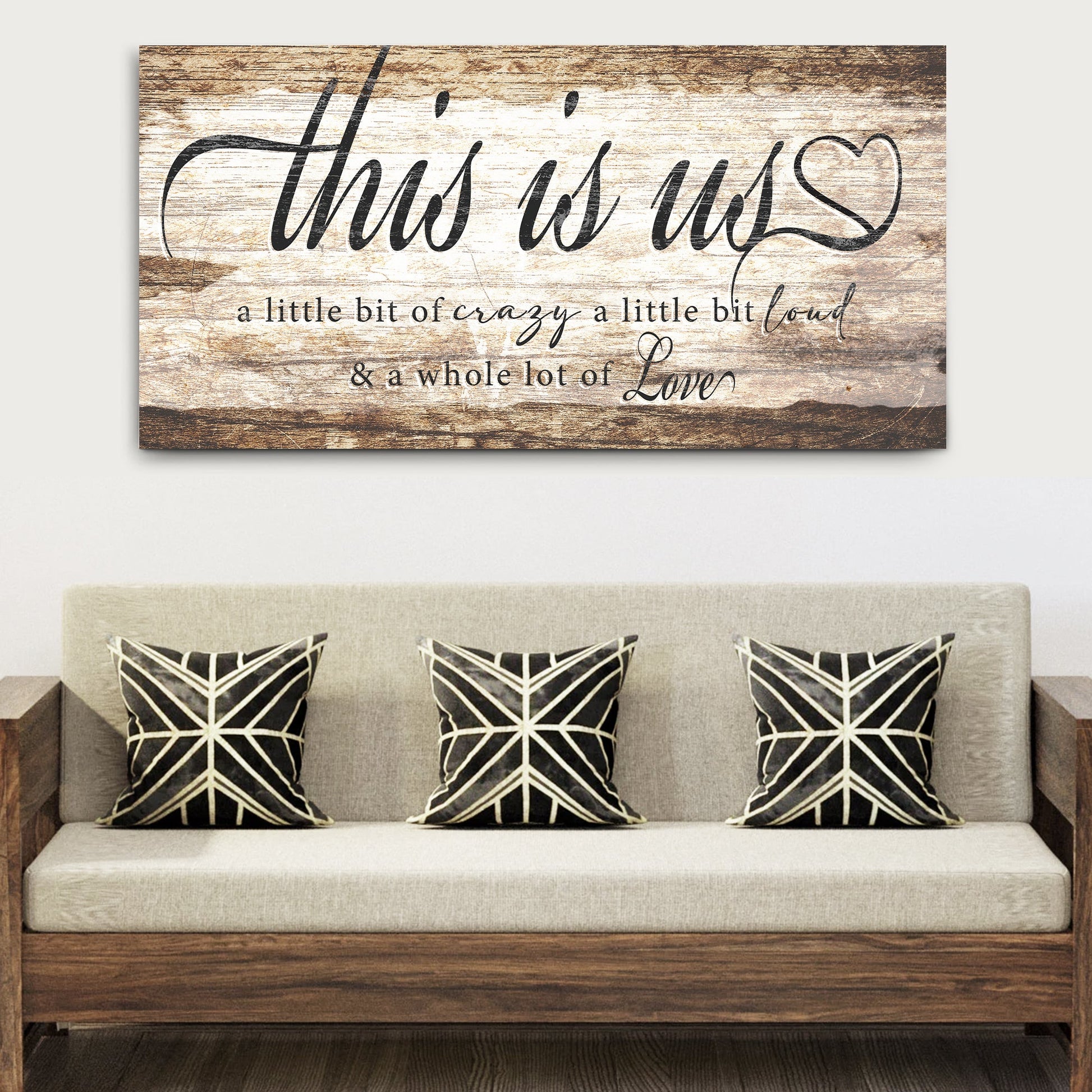 This Is Us Sign canvas with rustic wood backdrop, black cursive lettering and heart motif on Tampa Home & Garden Store