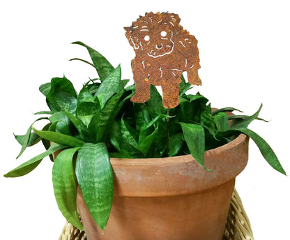 Maltese Dog Plant Stake in rusted metal cutout among green leaves in a terracotta pot on Tampa Home & Garden Store