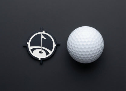 Premium Magnetic Metal Golf Ball Marker with black round frame beside a white golf ball on Tampa Home & Garden Store