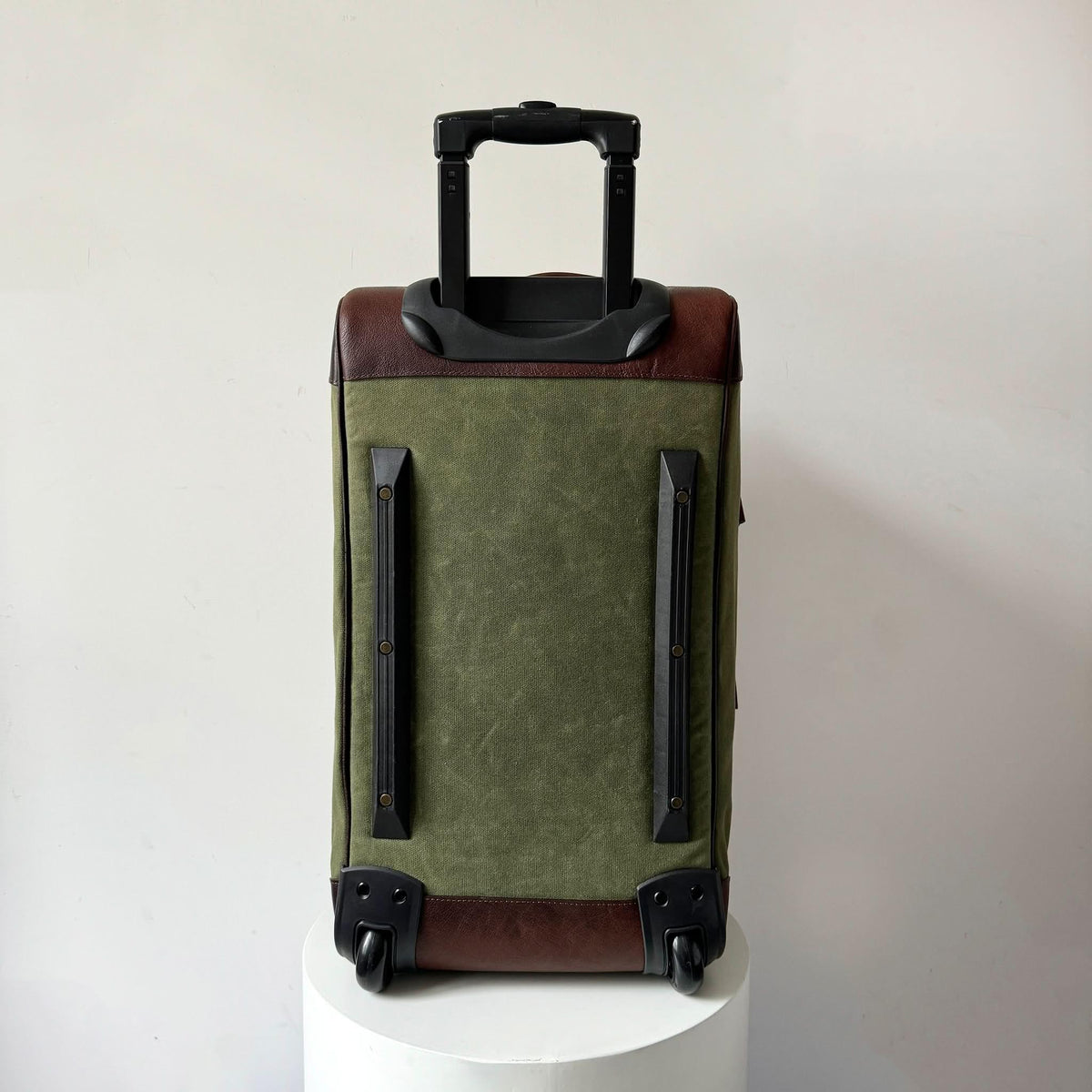 Maxwell waxed canvas rolling duffel bag olive green with brown leather trim and black handle on Tampa Home & Garden Store