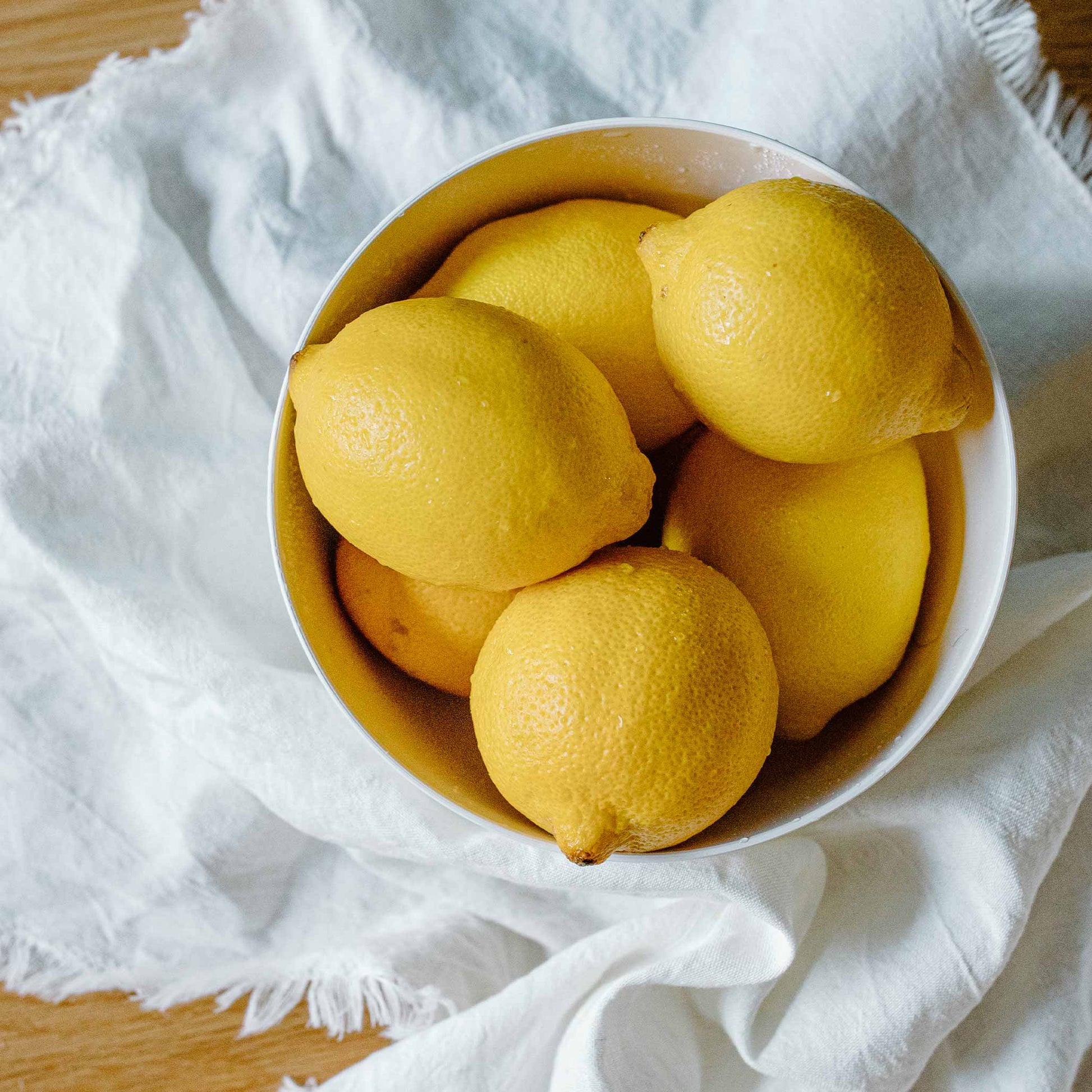 Improved Meyer Lemon Bush yellow lemons in a white bowl on a white cloth on Tampa Home & Garden Store