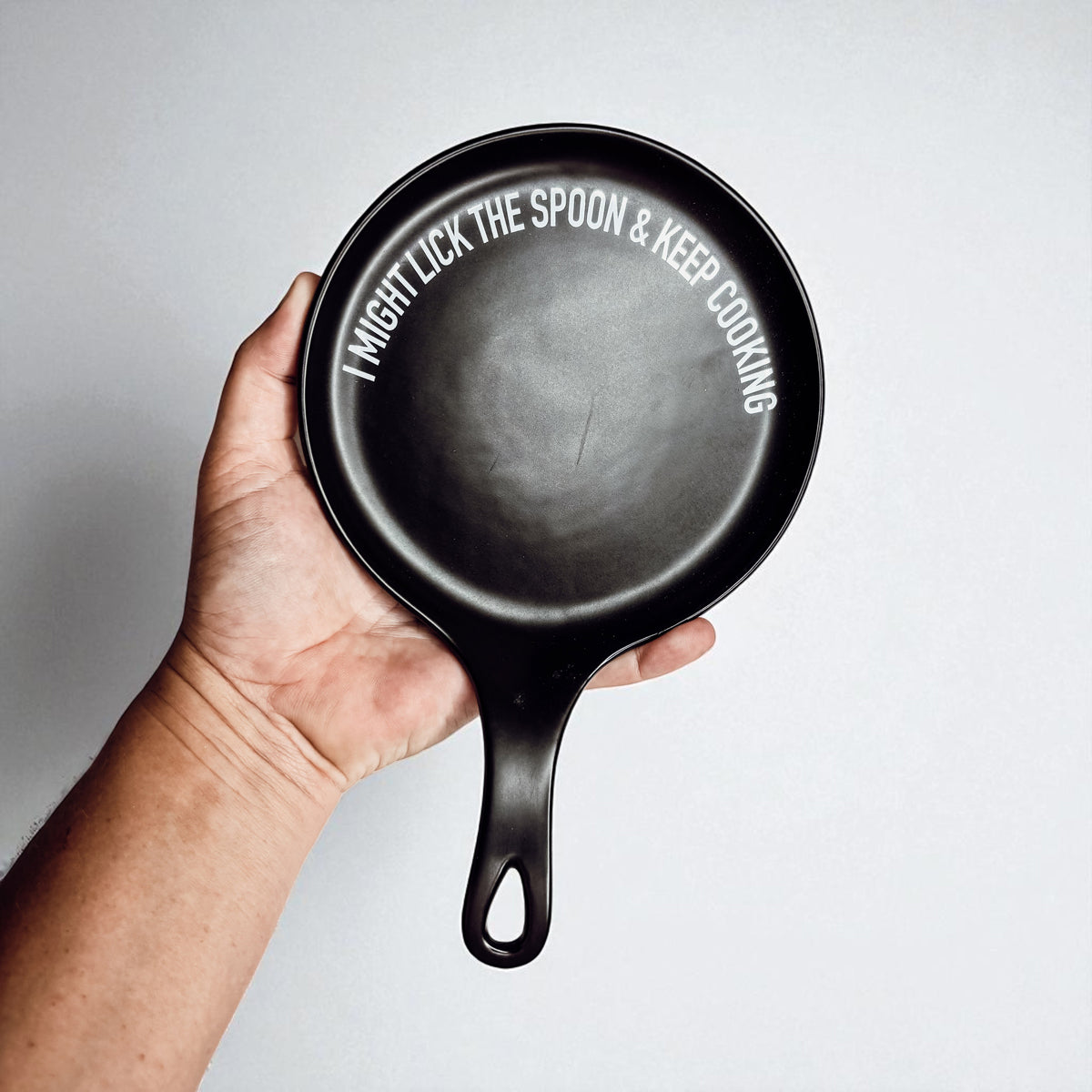 Gia Roma Lick the Spoon & Cook spoon rest, black round dish with white curved slogan along rim on Tampa Home & Garden Store