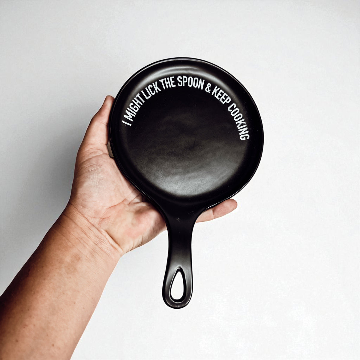 Gia Roma Lick the Spoon & Cook spoon rest, black round kitchen accessory with white text on Tampa Home & Garden Store
