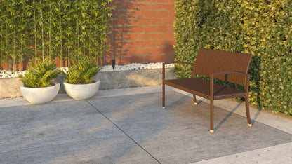 Miles Wicker Bench outdoor chair in brown wicker on a concrete patio with green hedges on Tampa Home & Garden Store