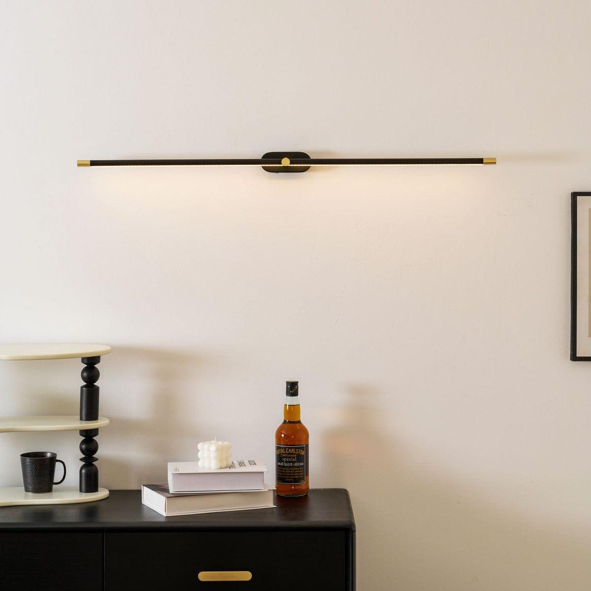 Moktan Sabai cordless LED wall light, black body with gold end caps mounted on wall on Tampa Home & Garden Store