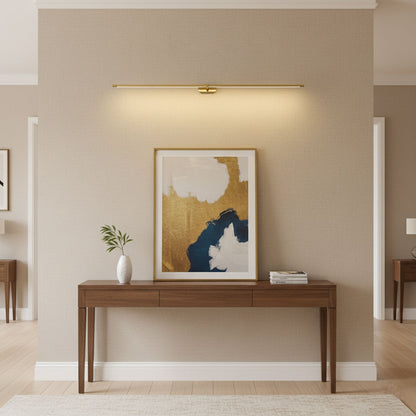 Gold linear LED wall lamp, wall-mounted bar light above console with framed abstract art on Tampa Home & Garden Store