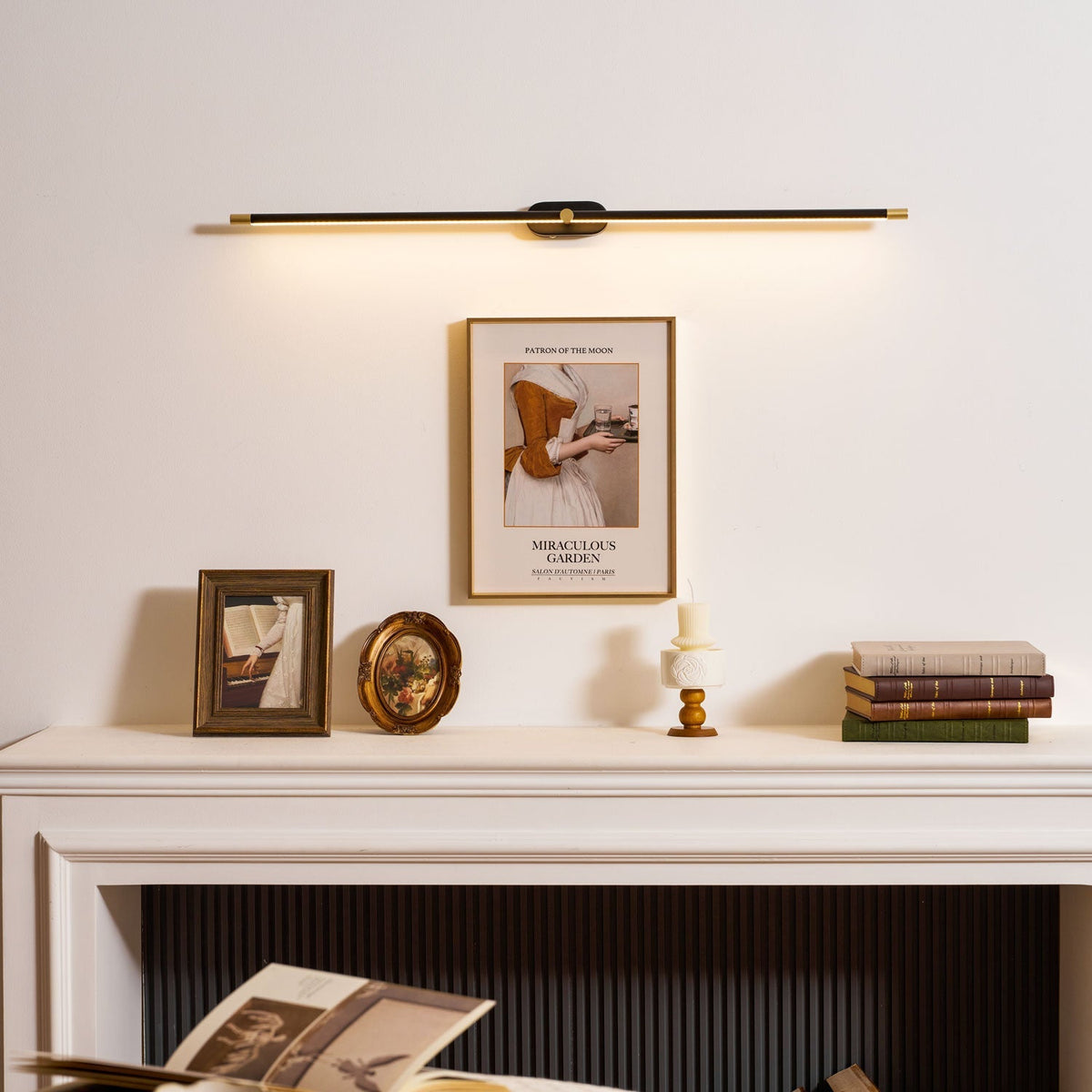 Rechargeable linear LED wall lamp in black with gold end caps, cordless with remote above mantel on Tampa Home & Garden Store