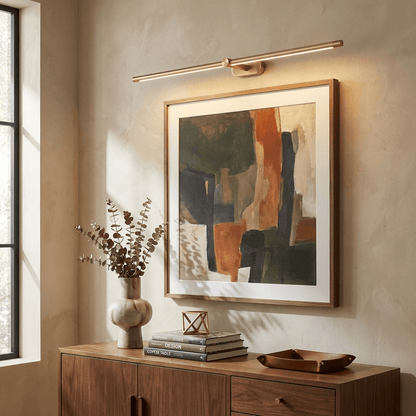 Rechargeable linear LED wall lamp with remote by Moktan Sabai in brass finish above art on Tampa Home & Garden Store