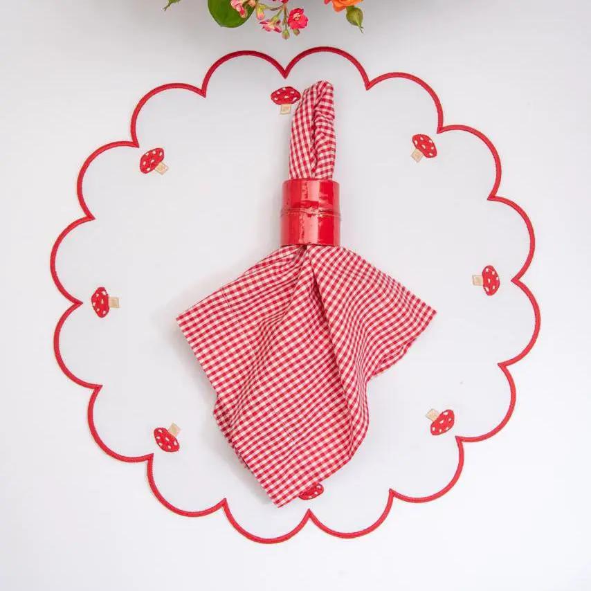 Mushroom placemat with red stitch border and mushroom motifs around edge by Talah Home on Tampa Home & Garden Store