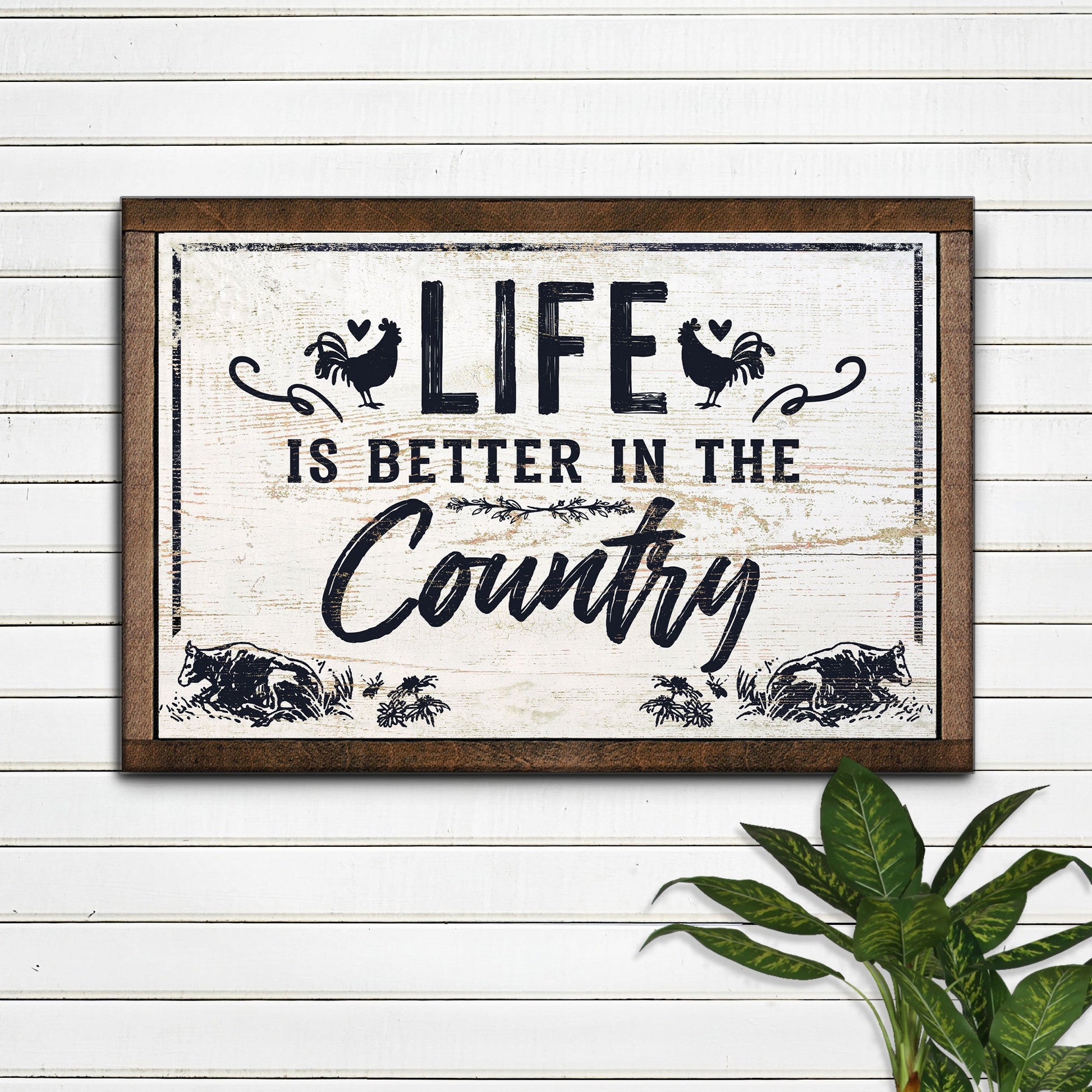 Life Is Better In The Country canvas sign with distressed black lettering and rustic frame on Tampa Home & Garden Store